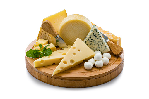 Wooden board with a variety of cheeses isolated on white background. Cheeses included in the composition are Manchego cheese, goat cheese, emmental cheese, Roquefort cheese, mozzarella cheese and Cheddar cheese. Predominant colors are yellow and white. High resolution 42Mp studio digital capture taken with Sony A7rii and Sony FE 90mm f2.8 macro G OSS lens
